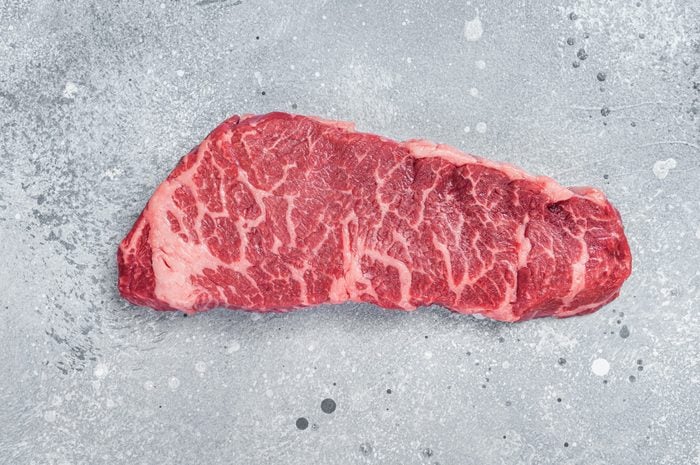 Raw Denver beef meat Steak. Gray background. Top view. Copy space